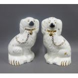 Pair of Beswick pottery chimney spaniels with painted faces and gilt collar chains, impressed