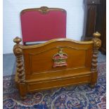 Oak bed, the headboard with a coronet crown and acorn leaf carving and red upholstery, the footboard