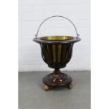 Mahogany circular basket planter with a brass insert and handle, on three bun feet, 39 x 40cm