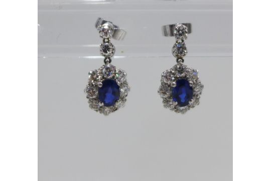 A pair of sapphire and diamond cluster earrings, with a central claw set sapphire within a - Image 1 of 4