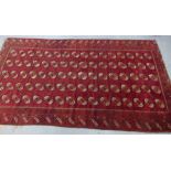 WITHDRAWN Early 20th century Afghan Ersari carpet, red field with five columns of sixteen guls,