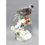 Chinese polychrome model of a bird perched on a stump, impressed backstamp, 27cm