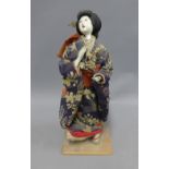 Japanese female figure with bisque head and hands, dressed in traditional costume, on a square