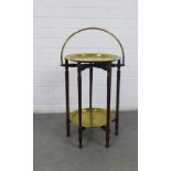 Folding two tier table on six turned legs, with two brass circular tiers, hooped handle, overall