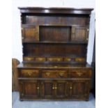 Oak dresser of large size, the plate back with two cupboards and five short drawers, the base with