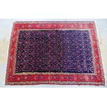 Eastern rug, blue field with repeating pattern within red borders,