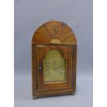 Walnut bracket clock with an arched case and brass berry finial with sawed tooth banding over an