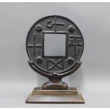 Bronze bi disc on wooden stand, overall height 23cm