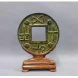 Bronze bi disc on wooden stand, overall height 21cm