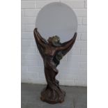 Bronze patinated resin figure of an Art Nouveau maiden, modelled standing holding a circular