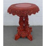 Chinese table, painted red to simulate cinnabar, with a circular top with overhanging pierced