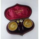 A cased pair of Victorian silver gilt salts, Birmingham 1892, complete with spoons