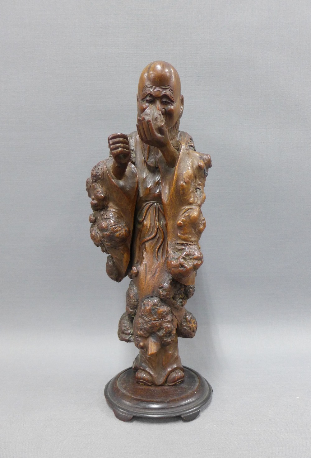 Rootwood carved figure of a Sage on a circular base, 32cm