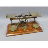 Set of Mordan and Co late 19th / early 20th century brass postal scales on a wooden base, 28cm