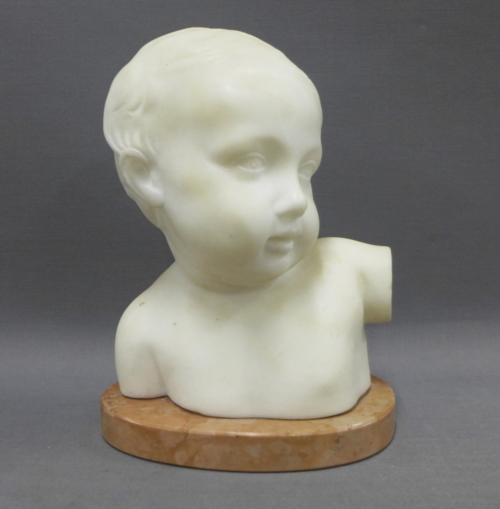 White hardstone head and shoulders bust of a young child on an pink oval marbled base, 22cm