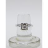 18ct white gold diamond ring with a brilliant cut square diamond within a surround of sixteen