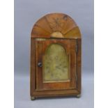 Walnut bracket clock with an arched case and brass berry finial with sawed tooth banding over an
