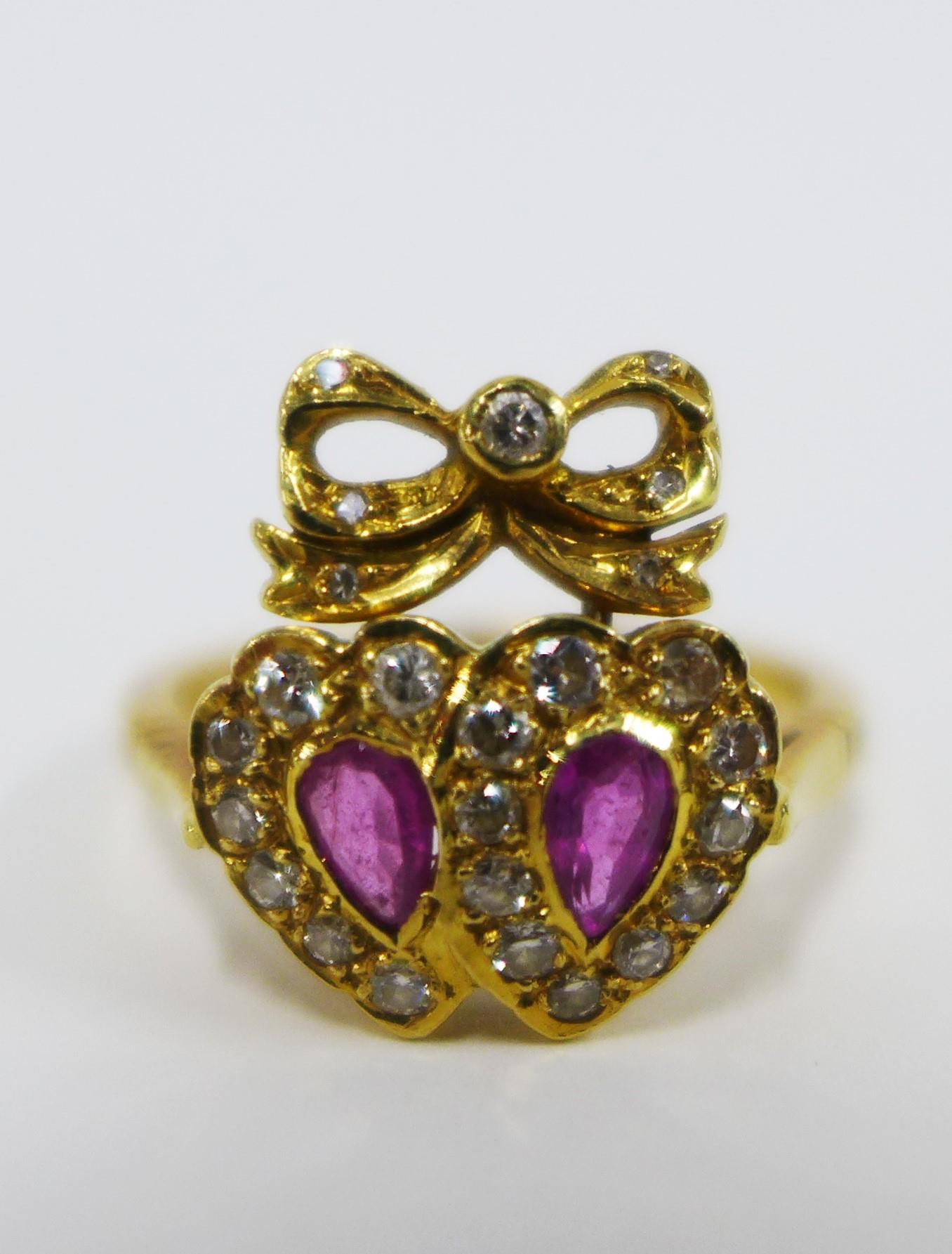 18ct gold ruby and diamond ring with a double heart and ribbon bow setting, London 1978