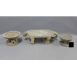 Stoneware zoomorphic stand and two circular stone stands, longest 50cm (3)