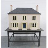 A large dollhouse which opens on both sides, on a supporting table. (a/f) House alone measures 124 x