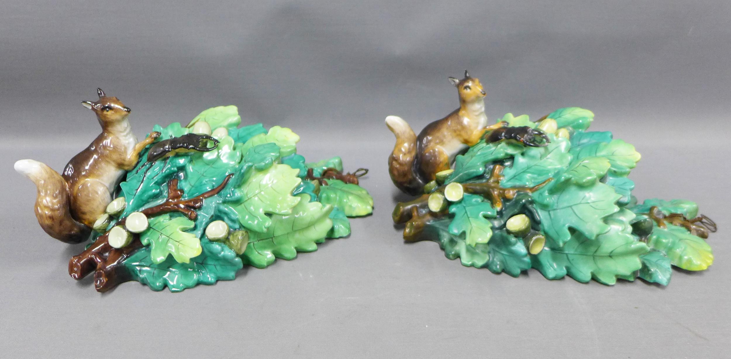 A pair of Continental porcelain squirrel and acorn leaf wall vases, with blue printed R