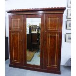 Victorian mahogany wardrobe, circa 1880, with a crenulated top over a central mirror flanked by