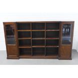 Attributed to Whytock & Reid, a walnut bookcase with inverted breakfront top over an open shelved