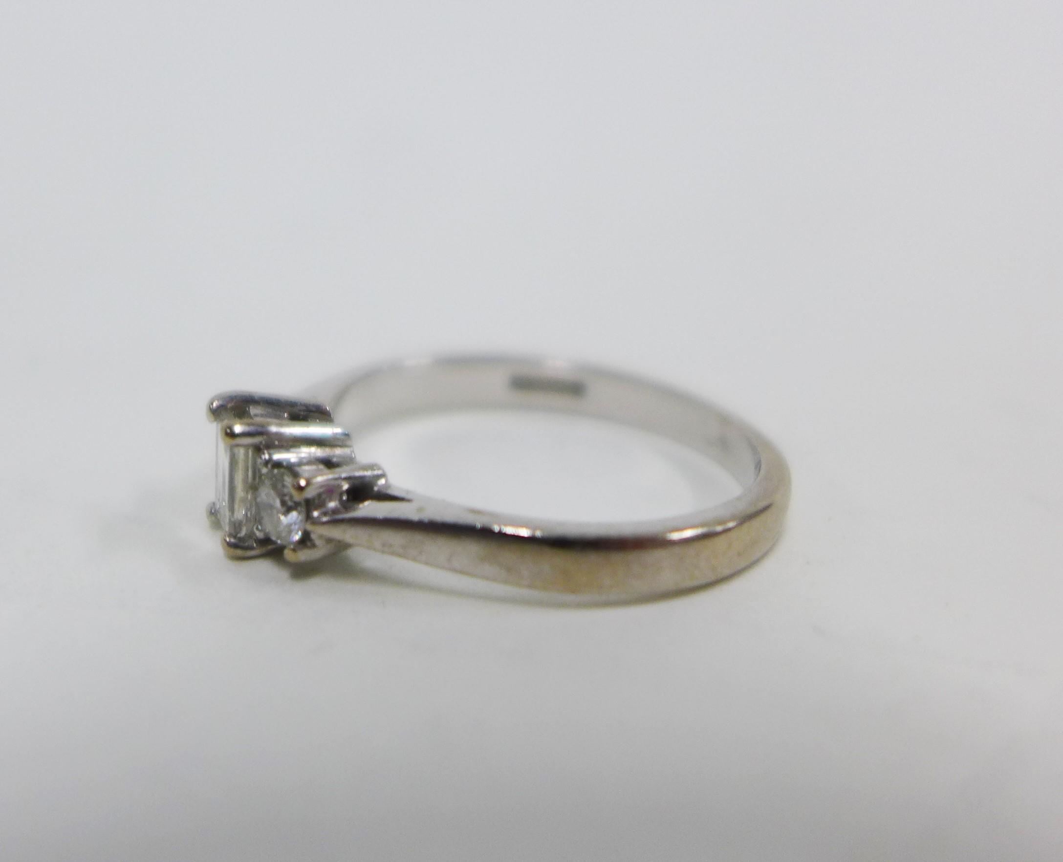 18ct white gold and three stone diamond ring, claw set with a baguette cut diamond flanked by round - Image 3 of 4