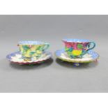 Meissen floral encrusted porcelain cups and saucers, painted with birds to the wells, blue crossed