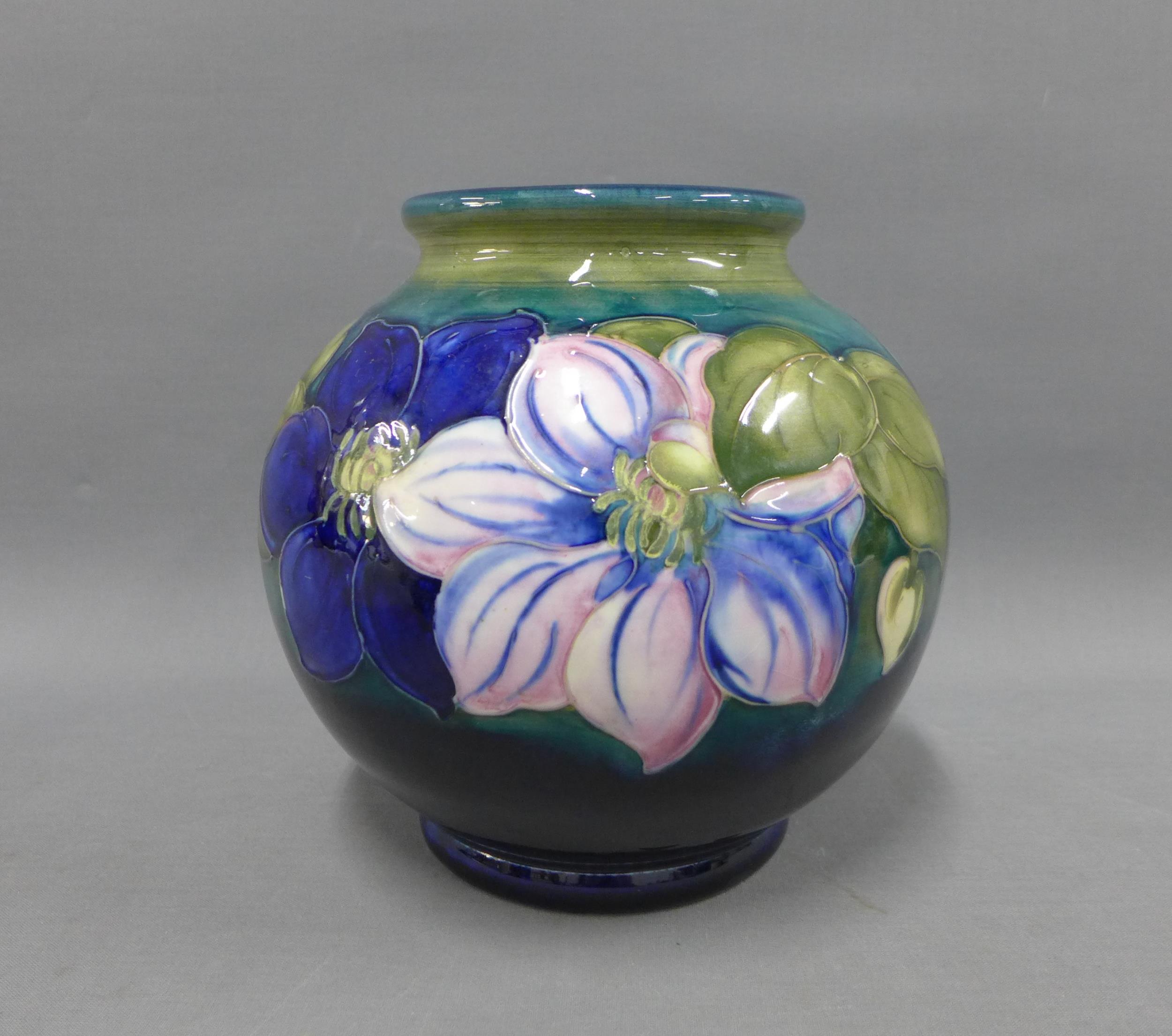 Moorcroft vase in Clematis pattern against a blue ground, impressed facsimile signature and