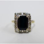 18ct gold sapphire and diamond cocktail ring, claw set with an emerald cut sapphire within a