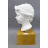 Head and shoulders plaster bust of a young girl, on a wooden plinth, signed indistinctly, 35cm