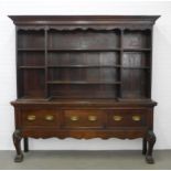 Late Victorian oak dresser with moulded cornice above open shelves, the base with three drawers,