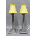 A pair of Epns Corinthian column table lamp bases, with yellow shades, 44cm including shades, (2)