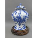 Chinese blue and white prunus jar and cover, 28cm high, with a hardwood stand