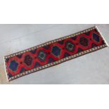 Kazak style runner with red field and seven medallions, 290 x 74cm