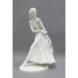 Art Deco porcelain female figure, modelled walking wearing a dress with green and red striped