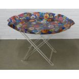 Spisani acrylic butlers table, the blue top with a pattern of Faberge eggs and with a wavy rim, on a