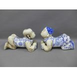 A pair of blue and white glazed pottery headrests, modelled as a boy and girl , 35cm long (2)