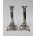 A pair of Edwardian Adam style silver plated desk candlesticks, on square bases with rams head