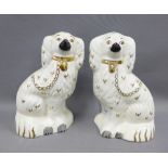 A pair of Beswick chimney spaniels, with painted eyes and gilded collar and chain, impressed