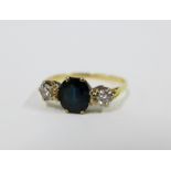 Sapphire and diamond three stone ring, with a central oval sapphire flanked by bright cut