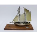 Modern silver model of a sailing boat and tender, London, circa 1980, Ammonite Ltd, on wooden