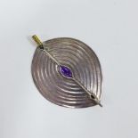 Unmarked white metal brooch of shield form with an amethyst cabouchon, possibly by Linda Lewin 8cm
