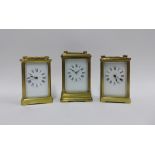 Three brass and glass panelled carriage clocks, tallest 16cm including handle (3)