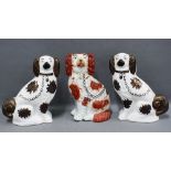 Pair of Staffordshire pottery chiney spaniels and another (3) 23cm