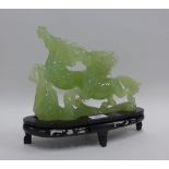 Jade carving of a horse on wooden stand, (repair to ear) 28cm long