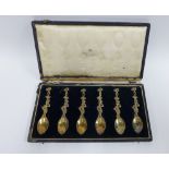 Victorian set of six silver gilt teaspoons, heavily cast and formed as harlequins beneath a tree,