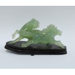 Carved jade figure of a galloping horse, on a wooden stand. 21cm