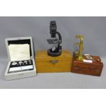 Small brass microscope, 12cm, with its mahogany fitted box, a black enamel microscope by Baker,